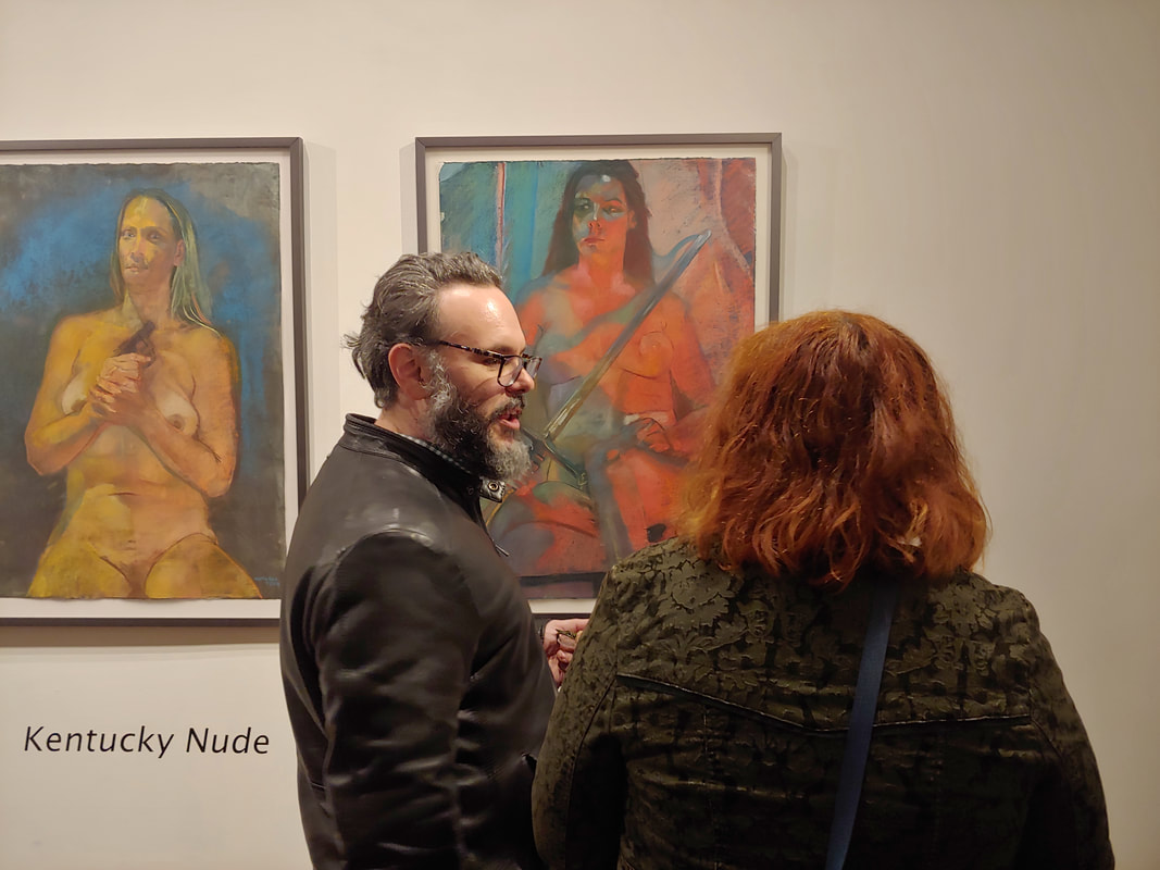 Two people stand in front of a painting at the Kentucky Nude reception.